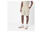 Un homme portant un short beige et des baskets.