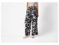 Pantalon large à motif zèbre noir et blanc et sandales à talons.