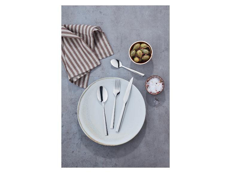 Une fourchette, un couteau et une cuillère sur une assiette, à côté d'un bol de câpres.