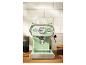 Machine à expresso vert menthe avec tasses en verre sur un comptoir en bois.