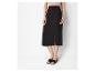 Jupe noire fendue et sandales plates : style minimaliste chic.