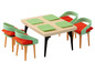 Une table en bois avec quatre chaises, des sets de table verts et des coussins orange.