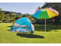 Une tente de plage pliable et un parasol arc-en-ciel sur l'herbe.