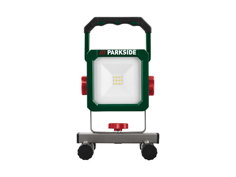Une lampe de travail LED Parkside verte avec une poignée et un support.