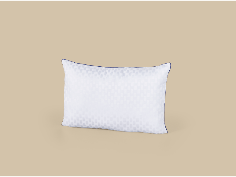 Oreiller blanc avec liseré bleu et motif à carreaux sur fond beige.