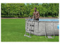 Un homme sort d'une piscine ronde, grise avec un motif de pierre.