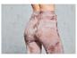 Une femme porte un legging rose avec un motif marbré.