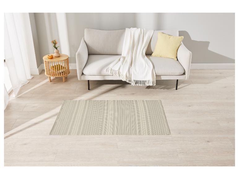 Tapis rayé beige clair dans un salon avec un canapé et un plaid blanc.