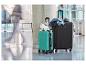 Deux valises, une noire et une turquoise, dans un aéroport.