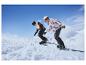 Deux personnes avec des casques et des lunettes de protection font du snowboard sur une pente enneigée.