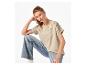 Femme en T-shirt beige clair brodé et jean bleu clair