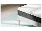 Matelas et sommier modernes sur un tapis bleu clair.