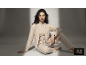 Femme en ensemble d'intérieur beige trois pièces assise au sol