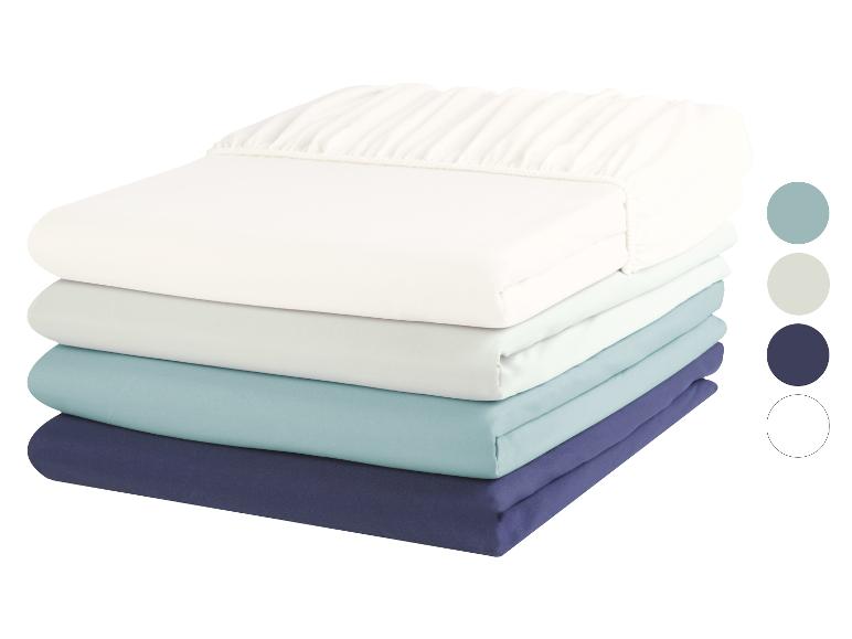 Une pile de draps blancs, bleu clair et bleu foncé.