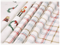 Nappes de Noël pliées avec motif à carreaux et motifs de casse-noisette.