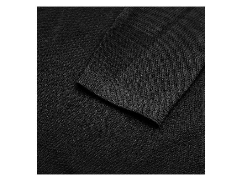 Manche d'un pull noir en maille fine avec un poignet côtelé.