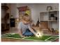 Garçon jouant avec un ballon de football lumineux sur un tapis de gazon dans une chambre d'enfant.