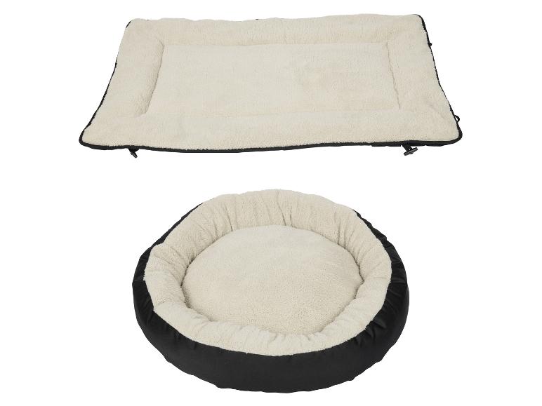Deux lits pour chiens noirs avec un pelage beige.
