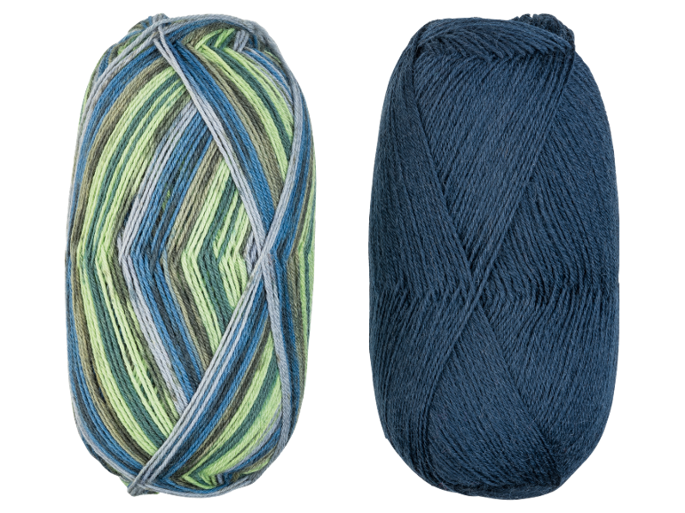Deux pelotes de fil, une multicolore en bleu, vert et gris, et une unie bleu foncé.