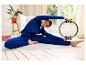 Une femme en tenue de sport bleue pratique le Pilates avec un cercle de Pilates.