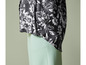Un chemisier noir à imprimé floral blanc et un pantalon vert clair.