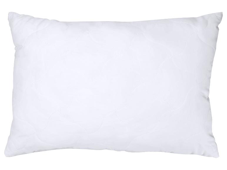 Oreiller blanc matelassé avec un motif ondulé, isolé sur fond blanc.