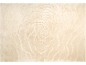 Tapis beige avec un motif en spirale en relief rappelant une rose.