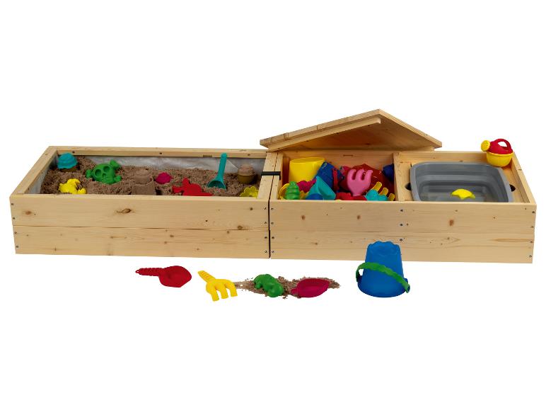 Un bac à sable en bois avec des jouets, y compris un arrosoir, une pelle et un seau.