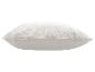 Coussin décoratif blanc avec motif de feuilles brodé.