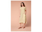 Une femme porte une robe maxi beige et des sandales marrons.