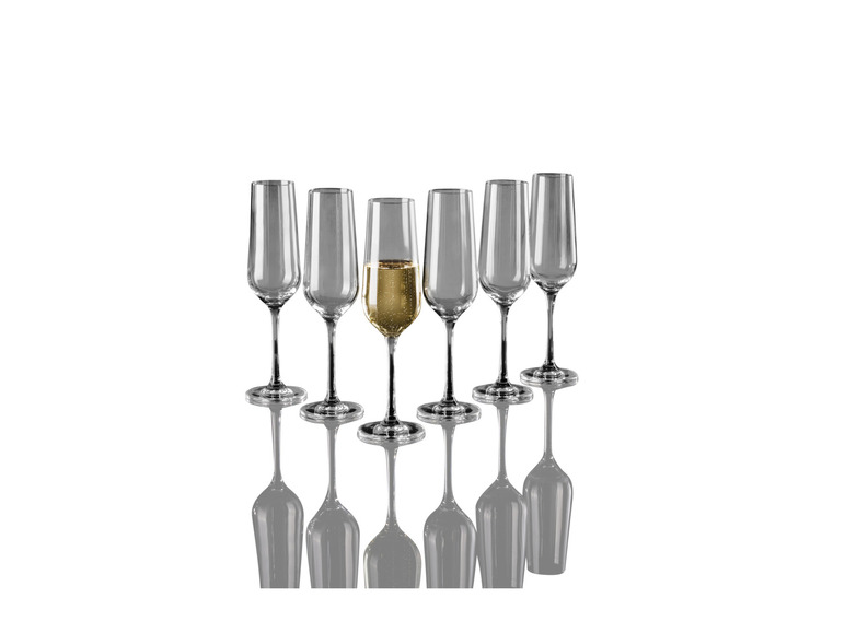 Une flûte de champagne avec une rangée de flûtes à champagne à côté.