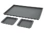 Ensemble de trois moules de cuisson en silicone gris, un grand rectangulaire et deux plus petits carrés.
