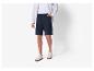 Un homme porte un short noir, une chemise blanche et des baskets blanches.
