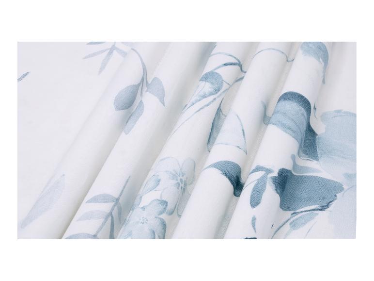 Tissu blanc avec un motif floral bleu clair et des plis doux.