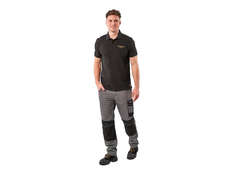 Homme en polo noir et pantalon de travail gris.