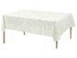 Nappe blanche avec un motif géométrique vert sur une table en bois.