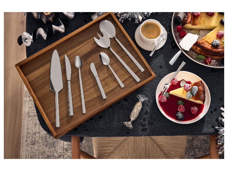 Ensemble de couverts à dessert sur plateau en bois avec gâteau et café.