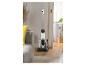 Aspirateur balai sans fil blanc avec fonction serpillère sur un parquet dans un salon.