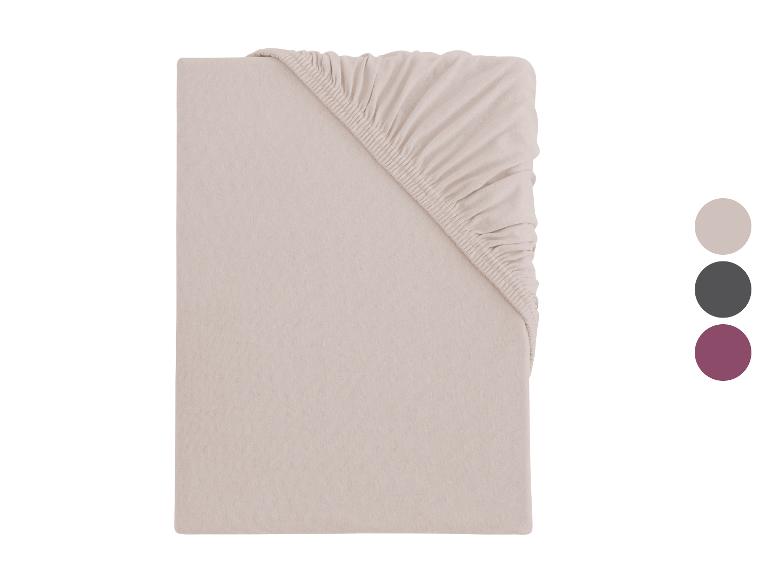 Drap-housse beige avec élastique, présenté plié, avec des échantillons de couleur.