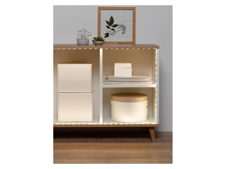Bande LED éclairant une étagère en bois moderne avec des décorations.