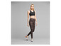 Femme portant un soutien-gorge de sport noir et un legging imprimé.
