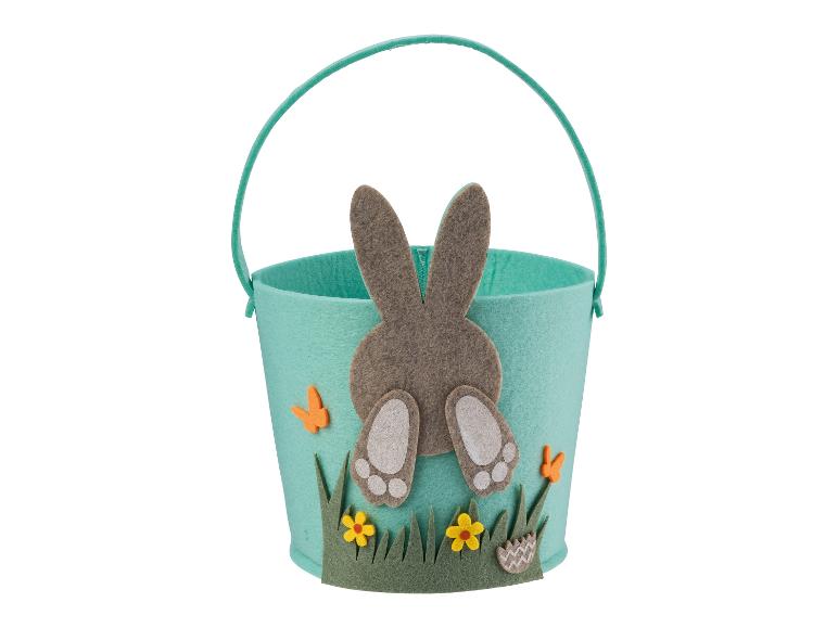 Un panier de Pâques vert clair avec un lapin et des fleurs.