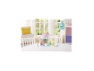 Ensemble de jeu de crèche avec château rose, animaux jouets et accessoires sur une table blanche.