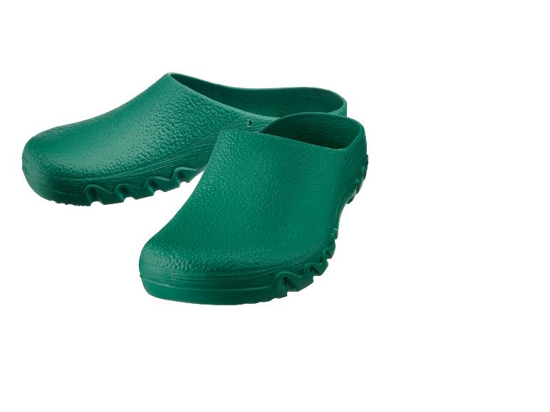 Une paire de sabots de jardin verts sur fond blanc.
