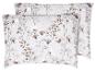 Deux oreillers avec un motif floral dans des tons beige et marron sur fond blanc.