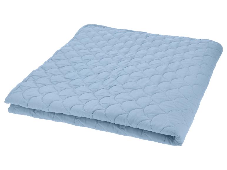 Couverture matelassée bleu clair pliée