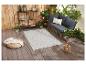 Tapis d'extérieur gris à motifs géométriques, salon de jardin et accessoires.
