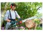 Un homme utilise une tronçonneuse Parkside pour couper du bois.