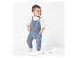 Un jeune enfant porte une combinaison en tricot bleu.
