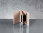 Un porte-monnaie en cuir rose ouvert sur une table.